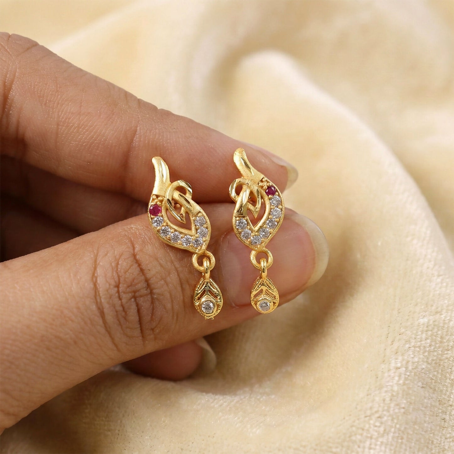 Side view of gold finish leaf design drop earrings