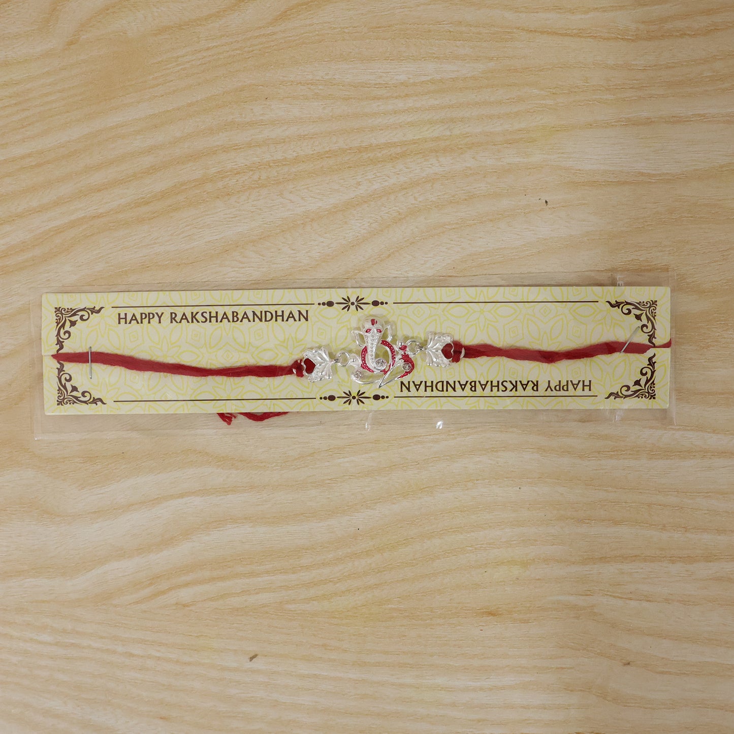 Silver Ganesha Rakhi with Red Stone Hearts and Deep Velvet Look