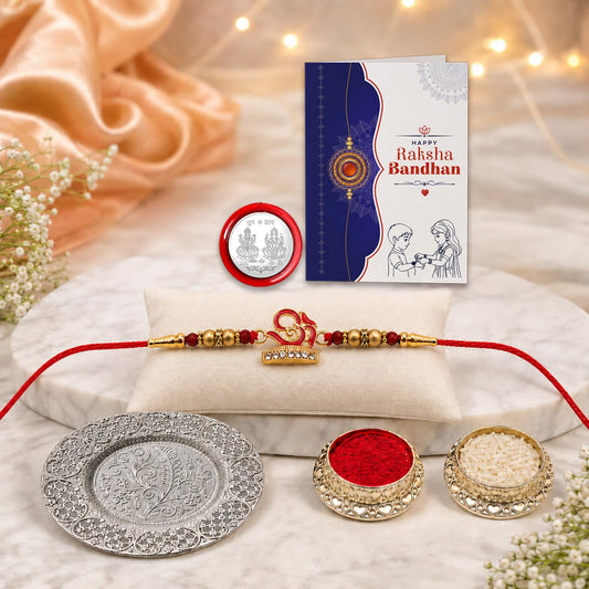 Multicolor OM Rakhi gift hamper with silver pooja thali, roli chawal, and greeting card for Raksha Bandhan.