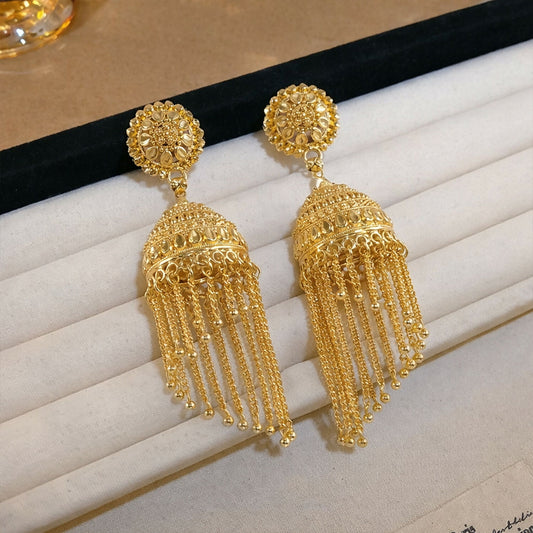 Traditional gold tone jhumka earrings with red bead tassels