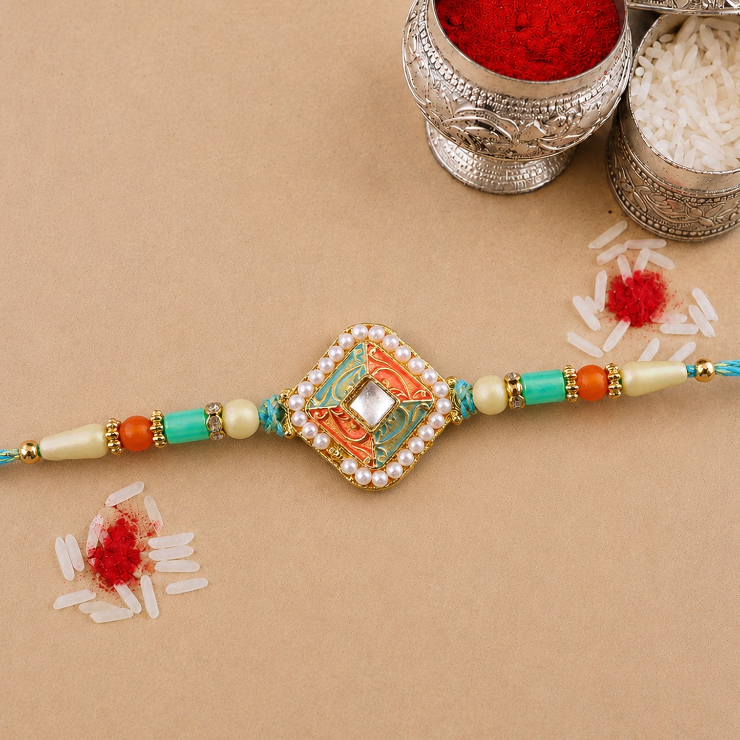 Pearl Bordered Meenakari Pendant Rakhi with Orange and Teal Enamel