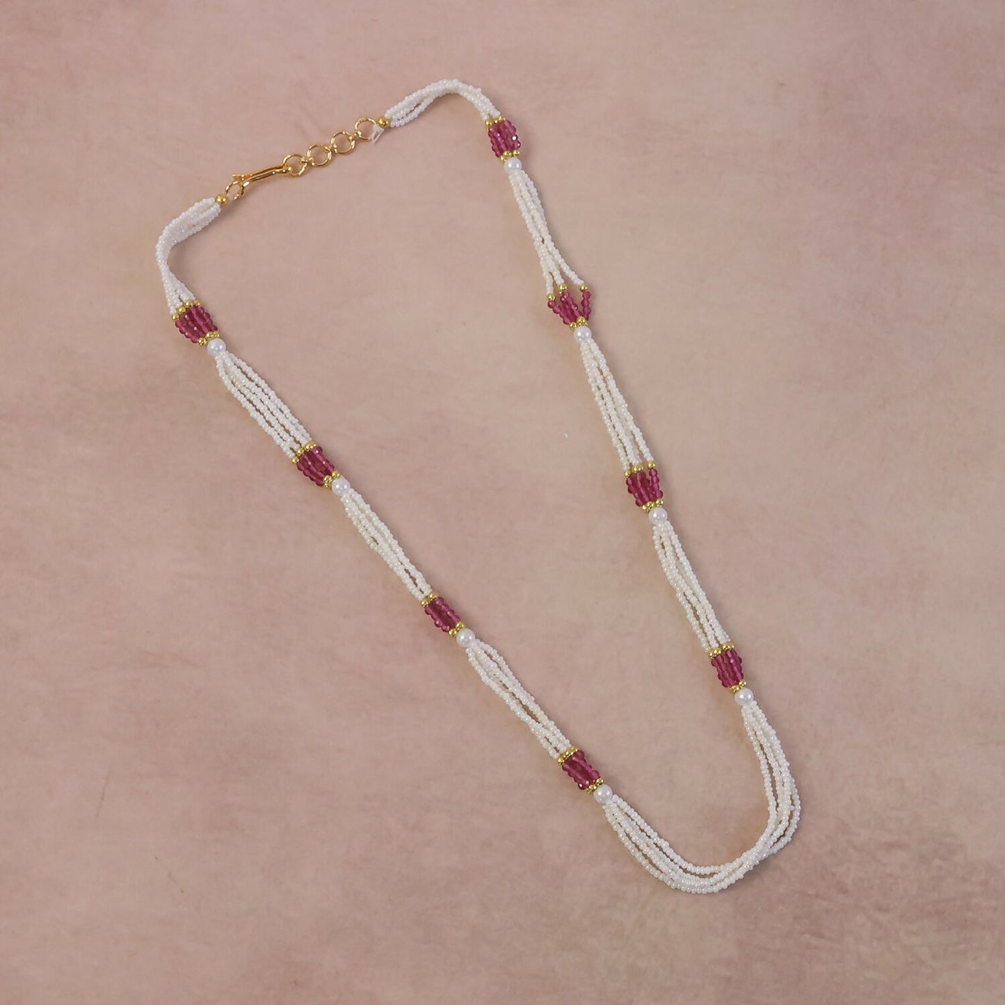 Elegant multi-strand mala necklace displayed on stand