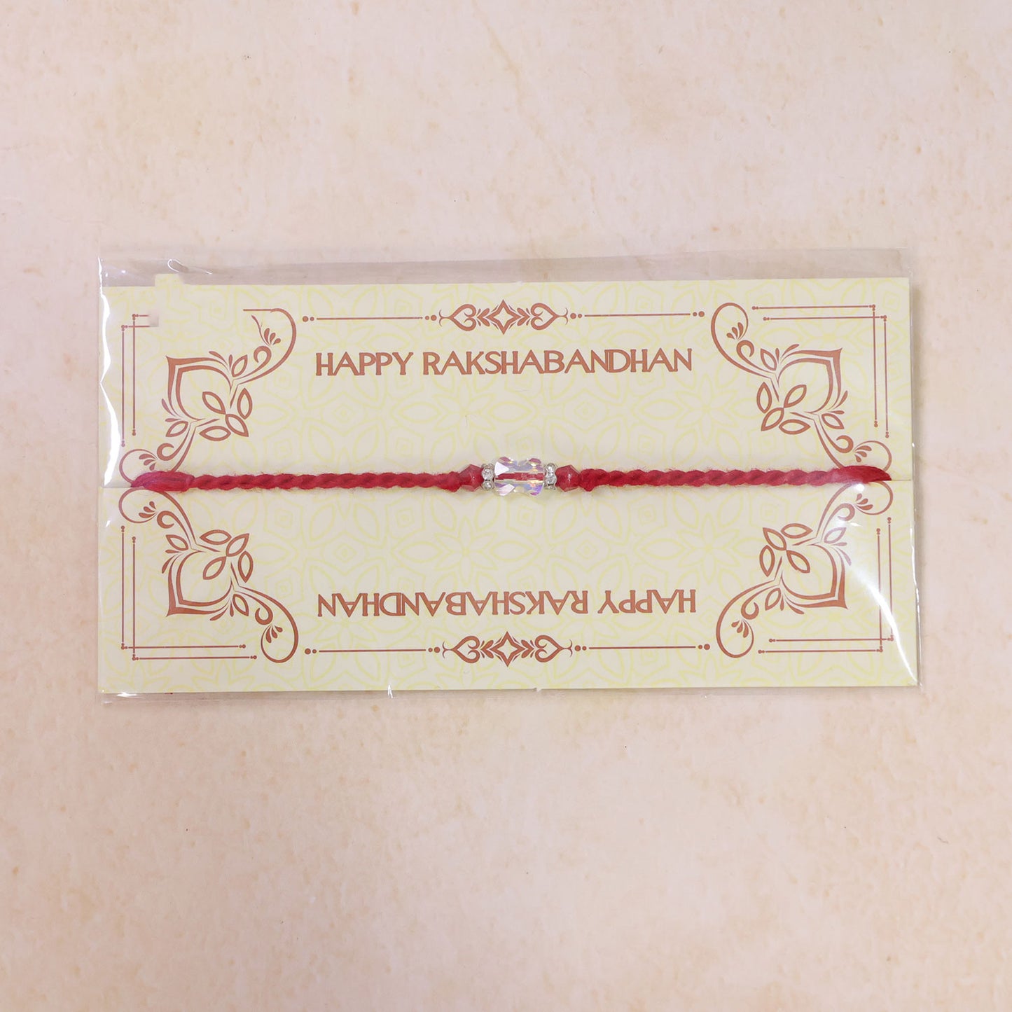 Red Thread Rakhi with an Iridescent Bow-Tie Shaped Crystal Bead