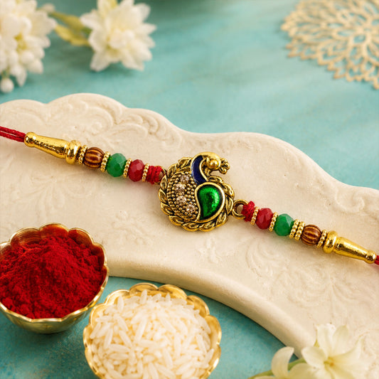 Close-up of Green Peacock Paisley Rakhi with golden detail and festive beads.