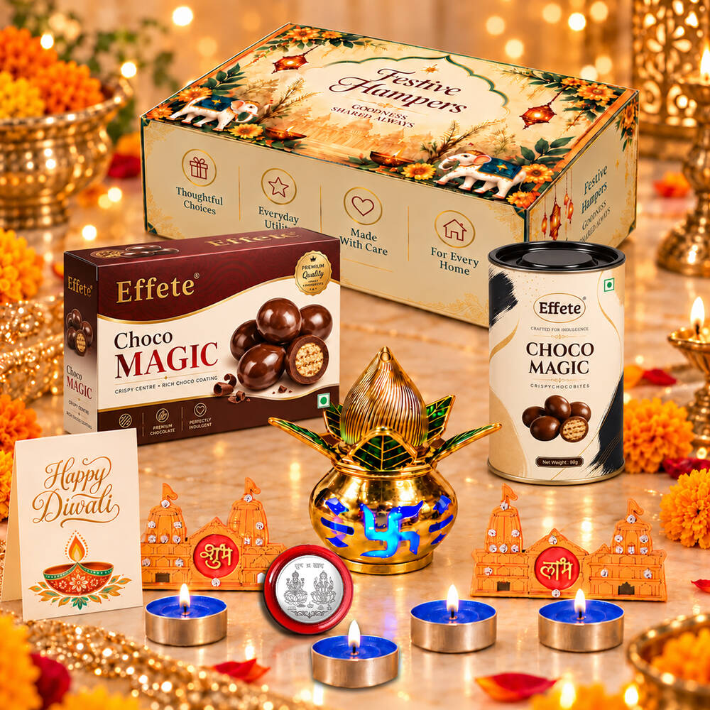 A Diwali gift set with a decorative box, chocolates, a golden kalash, tealights, and orange temple-shaped decor on a wooden