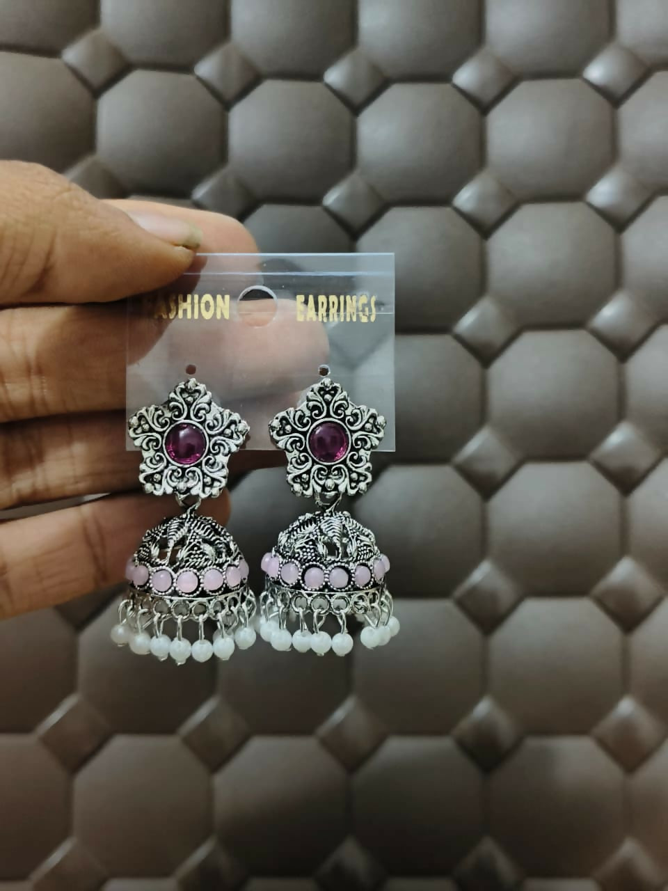 Model wearing oxidized silver jhumka earrings with purple stones and pearl drops