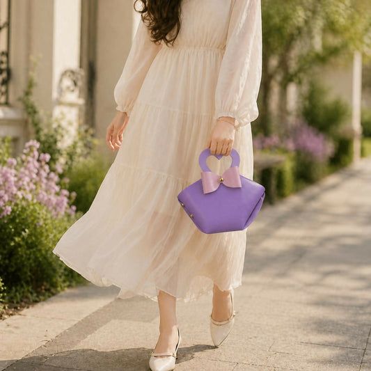 Stylish purple mini handbag with heart handle and bow accent