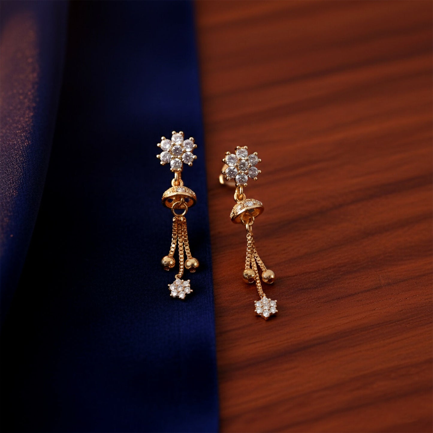 Side angle of gold-tone floral crystal drop earrings showcasing delicate chain tassels and bead accents