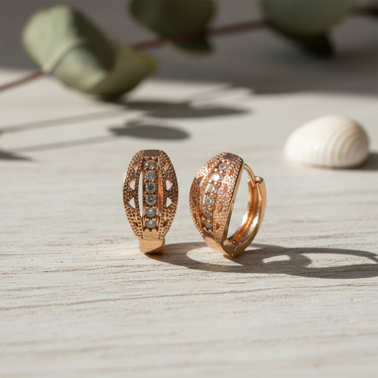 Detailed view of the CZ stones studded on gold finish hoop earrings