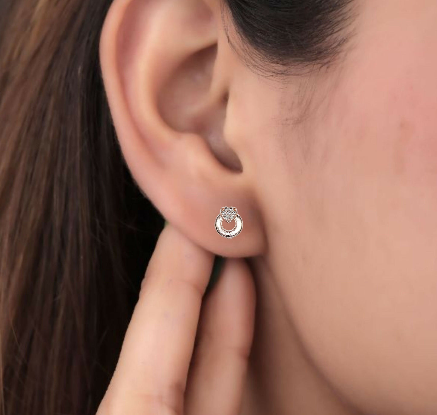 Silver circle stud earrings featuring heart-shaped cubic zirconia stones on white background