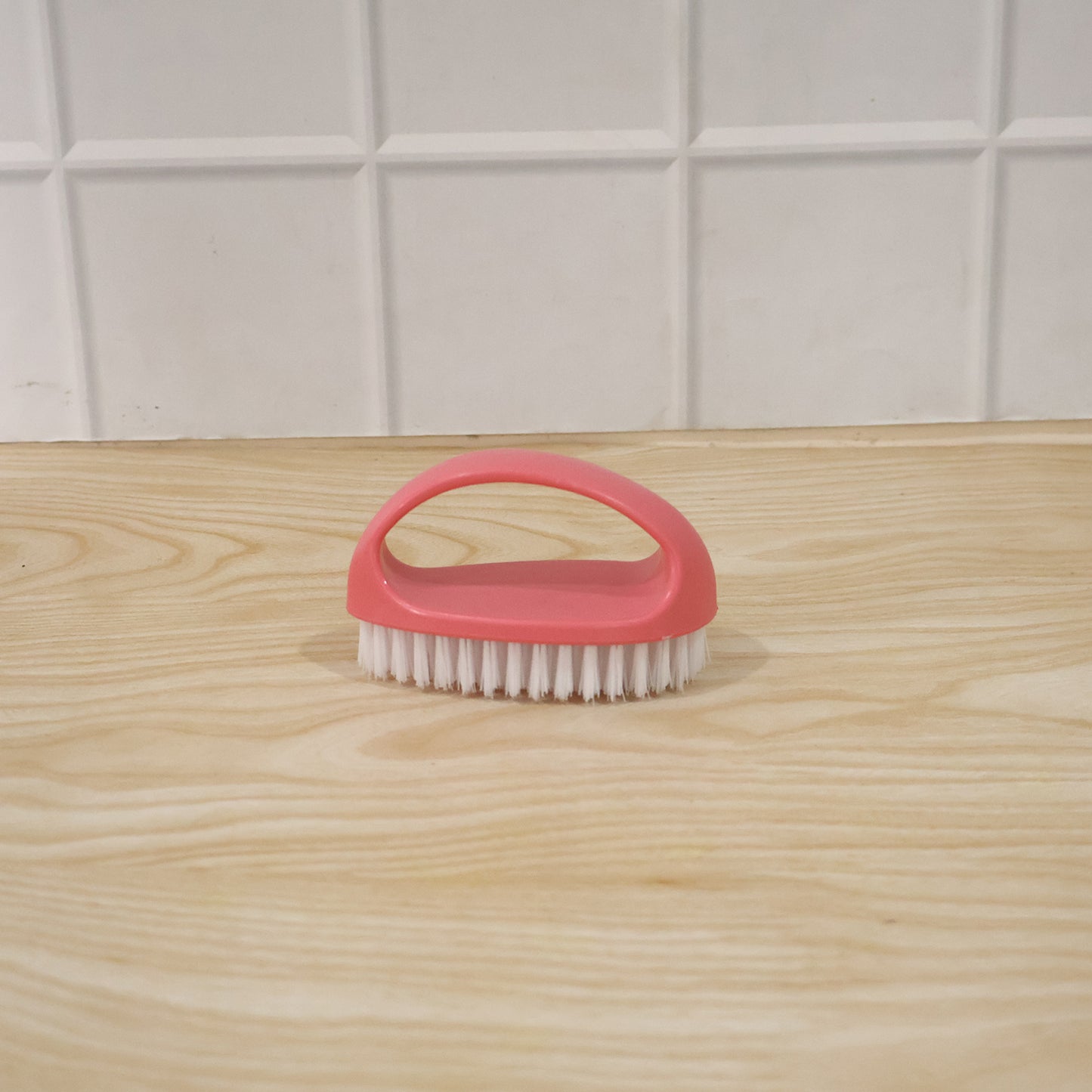 Person using multi-purpose cleaning brush on a surface