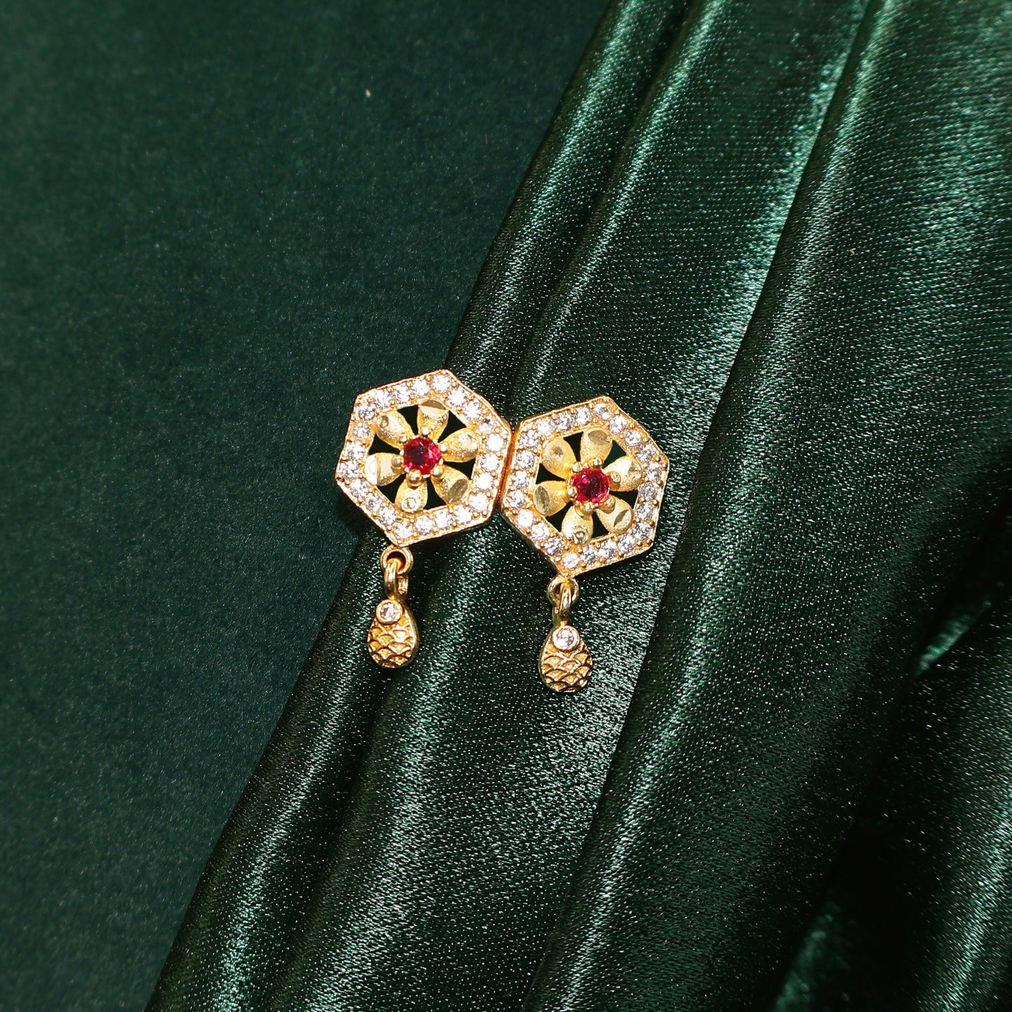 Elegant gold plated necklace with hexagon stone pendant resting on a surface.