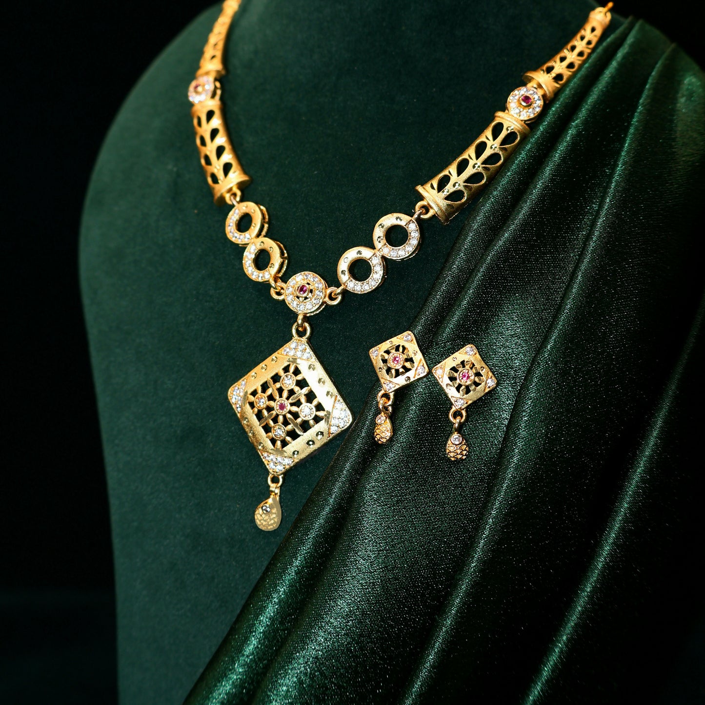 Closeup of gold plated square pendant necklace with intricate filigree work and AD stones