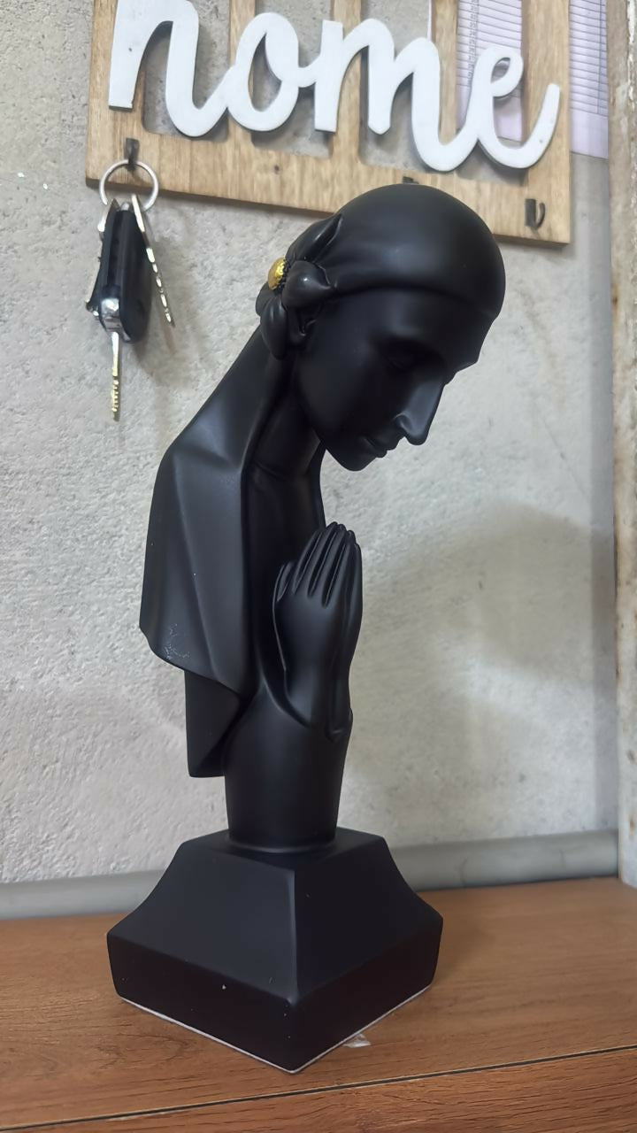 Praying lady sculpture placed on shelf in home décor setting