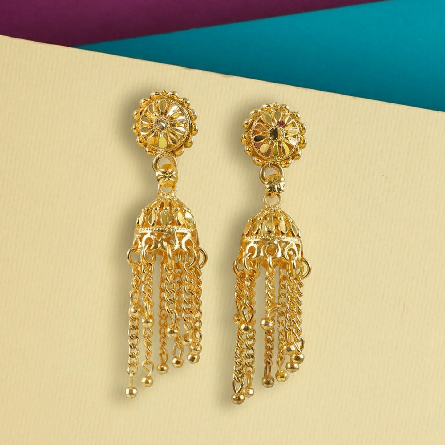 Side view of gold plated tassel jhumka earrings showcasing hanging chains