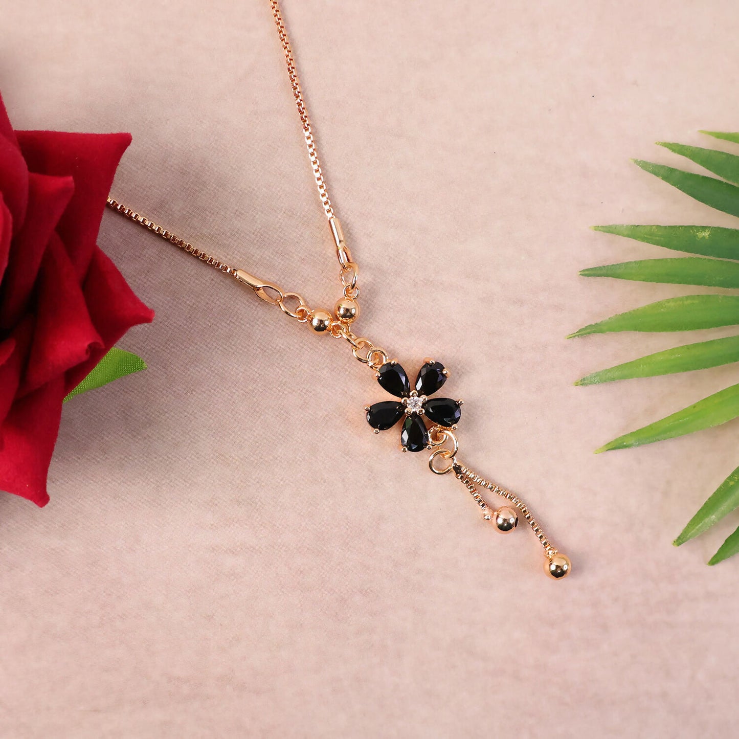 Elegant drop detail of gold finish black floral pendant necklace