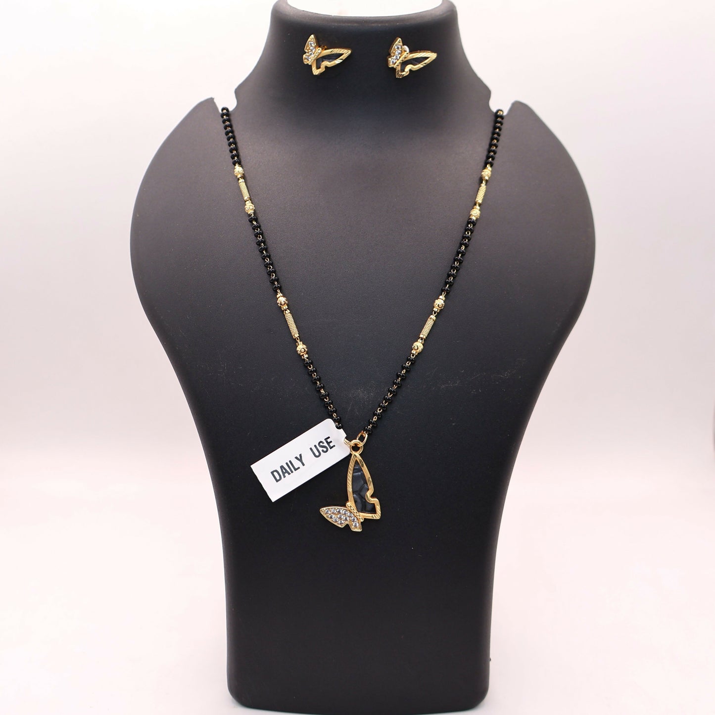 Matching gold-plated butterfly earrings paired with the mangalsutra necklace