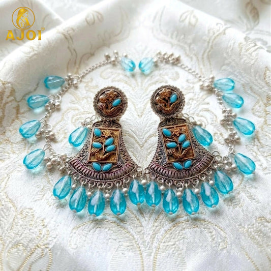 Model wearing antique oxidised floral chandbali earring with sky blue crystal drops