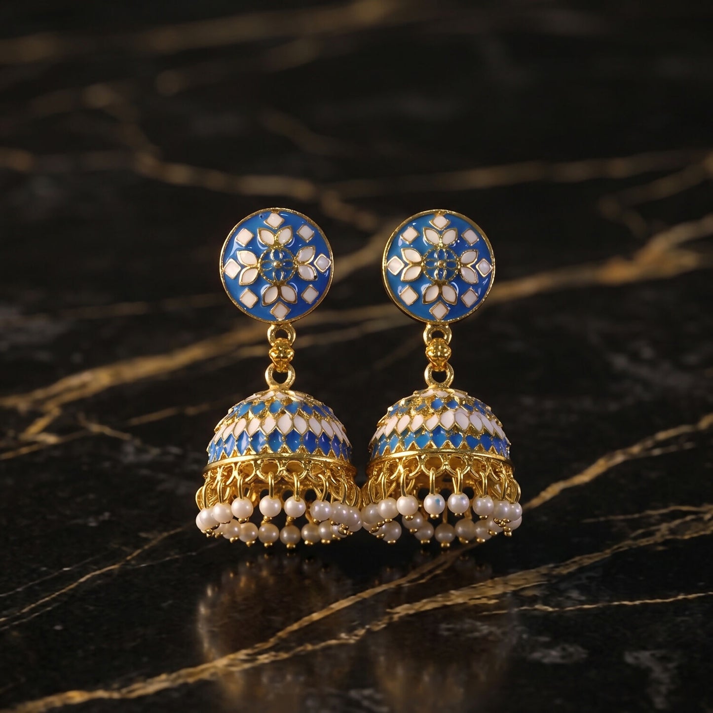 Blue stud jhumka earrings displayed on festive background