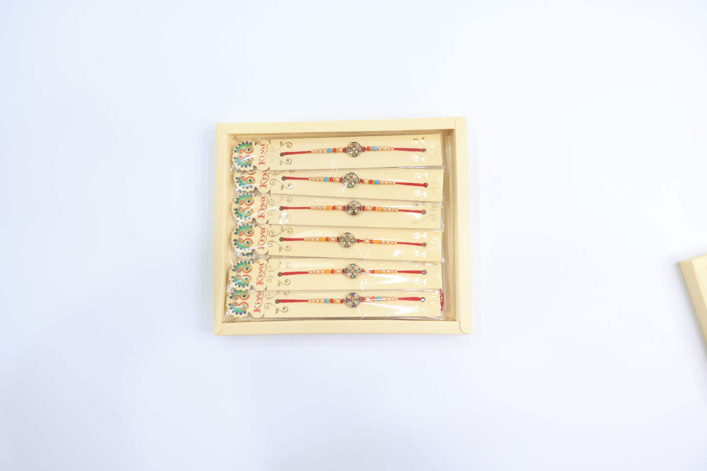 Combo Pack of 12 Antique Floral Designer Rakhis with Red-Blue Pearl Beaded Threads – Festive Gift Edition