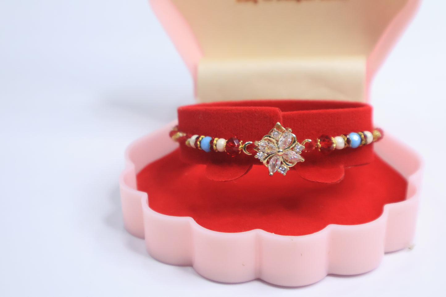 Elegant Floral Sparkle Rakhi with Red & Blue Beads