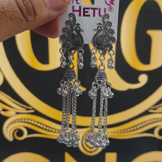 Elegant oxidised peacock long chain jhumka earrings styled on display