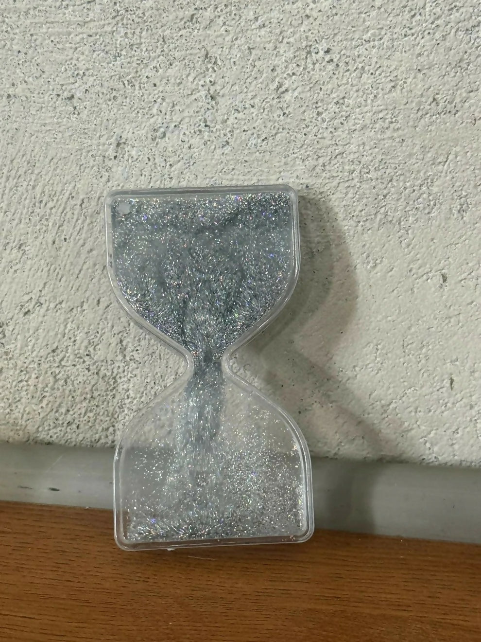 Silver glitter hourglass timer placed indoors