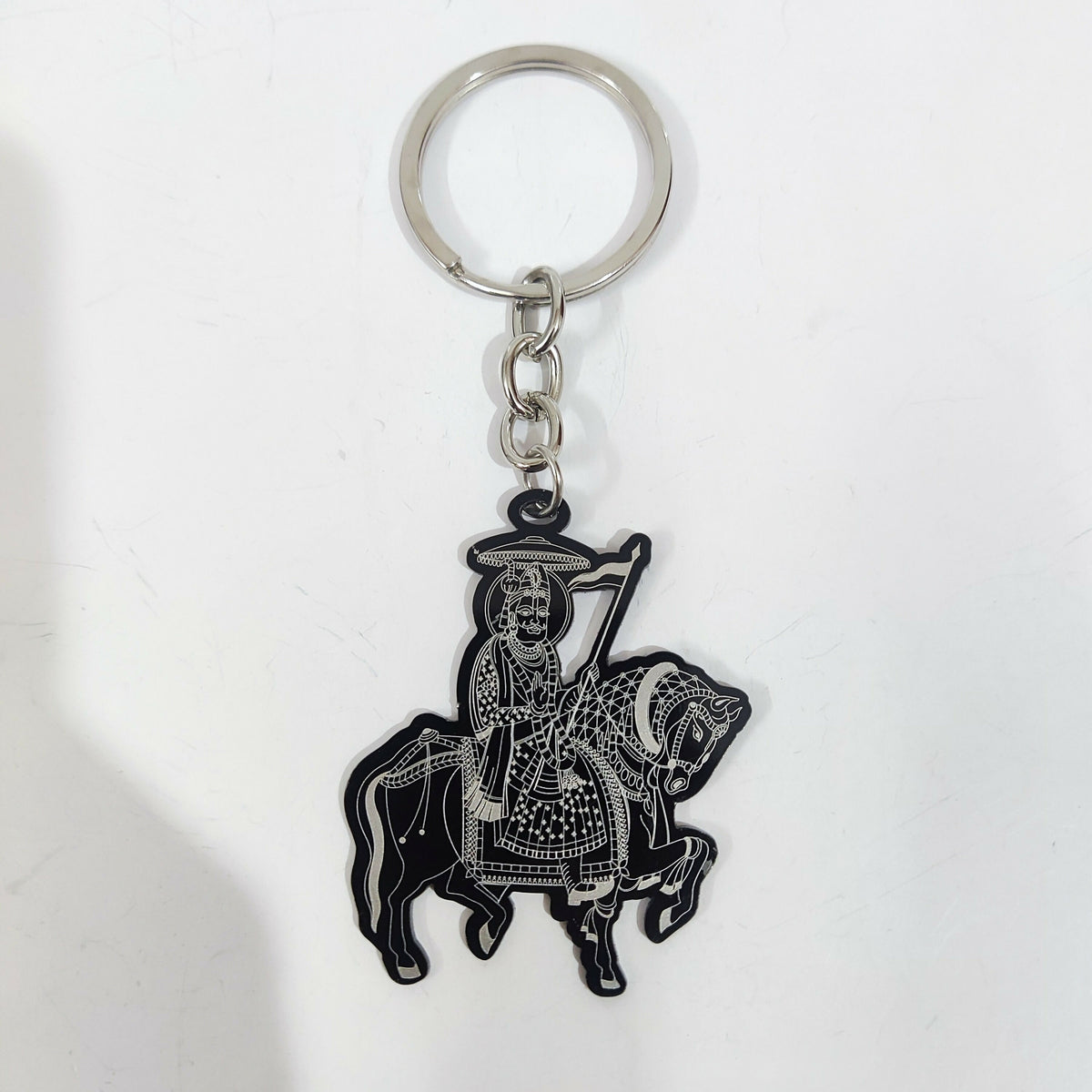 Traditional horse rider keychain with flag motif on a reflective surface
