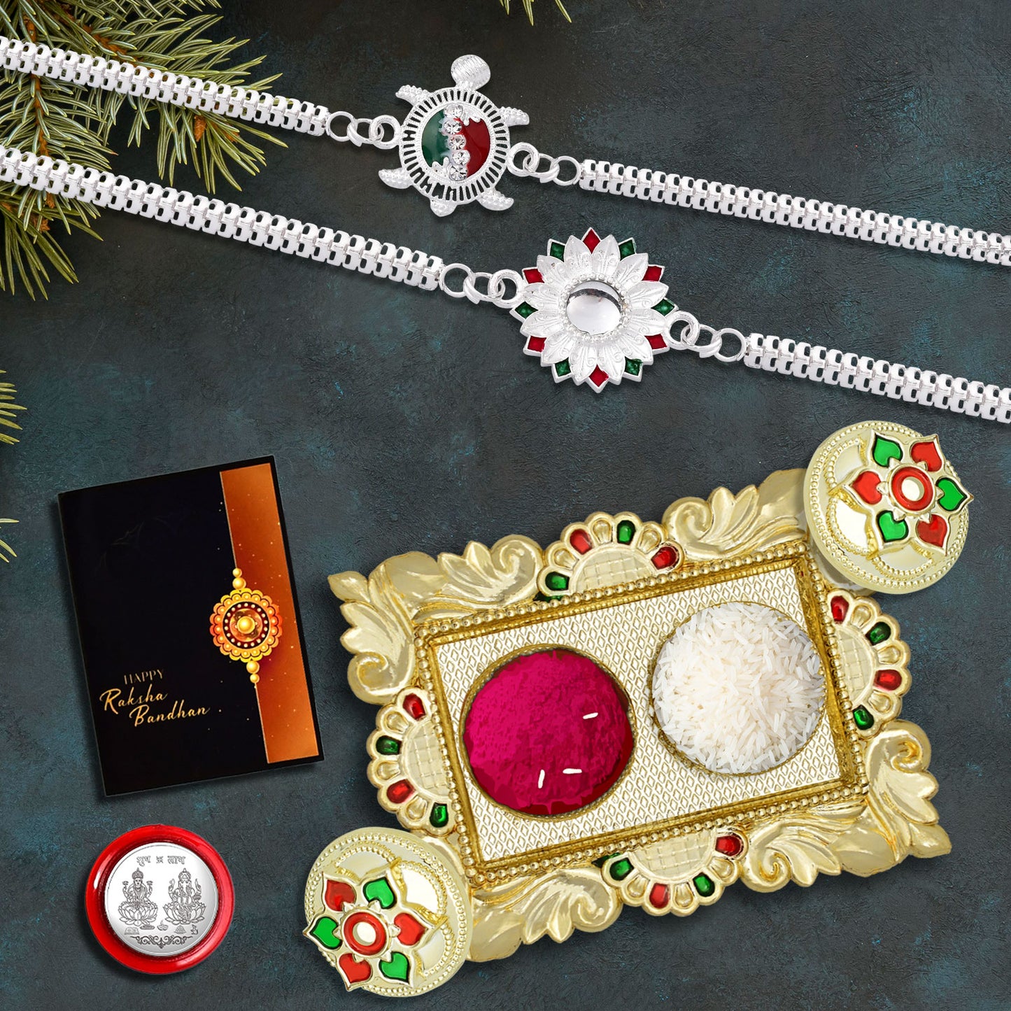 Two designer silver rakhis in a festive gift set