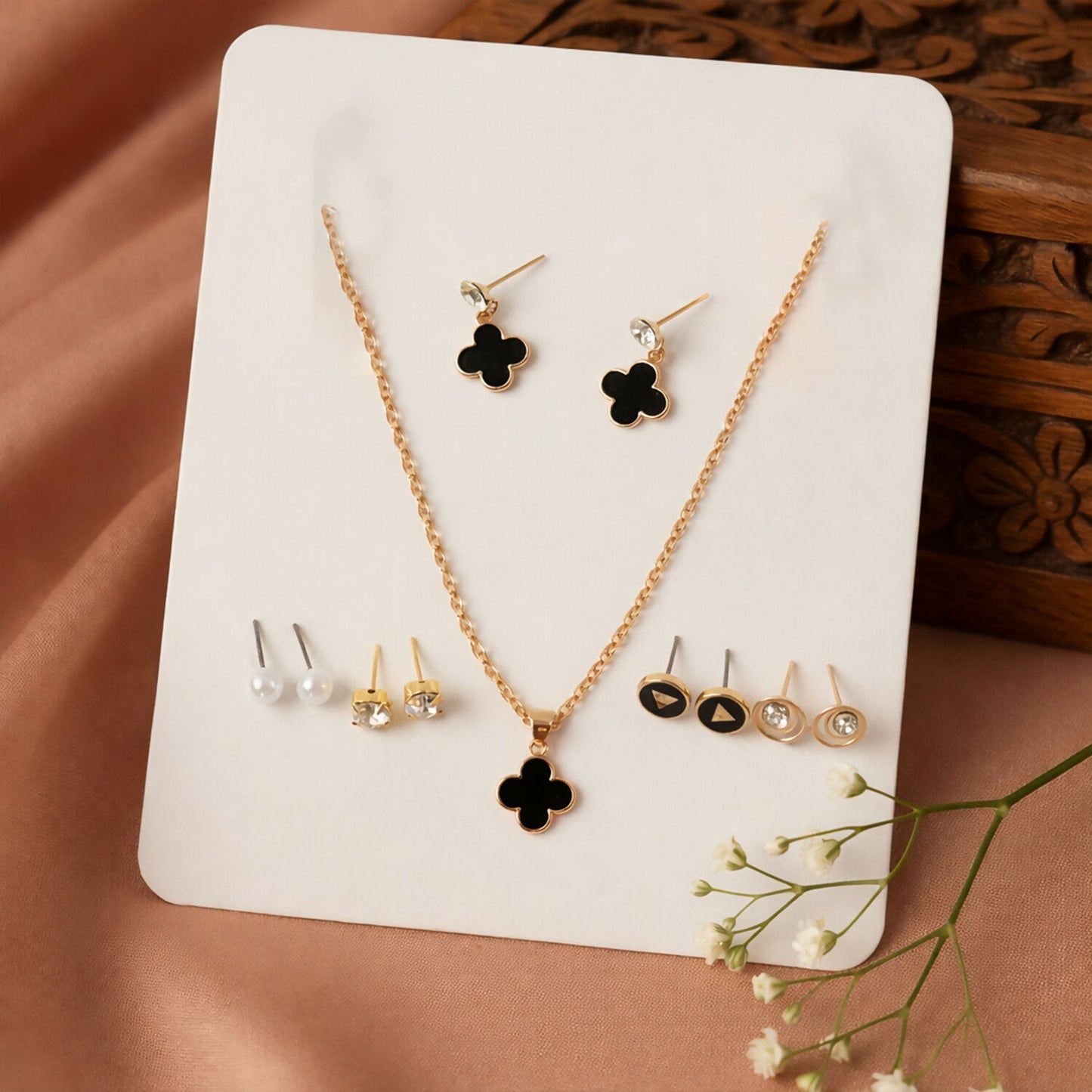 Elegant gold plated black clover pendant necklace detail with matching stud earrings