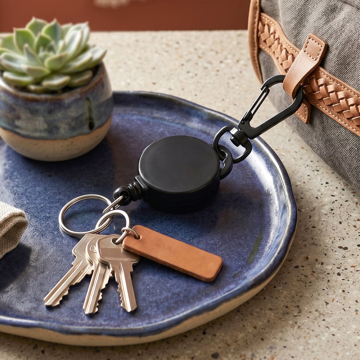 Durable retractable keychain hanging from bag strap