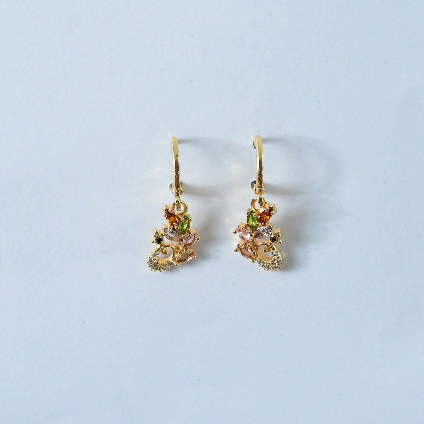 Detailed image of the peacock swirl and teardrop charm on gemstone earrings