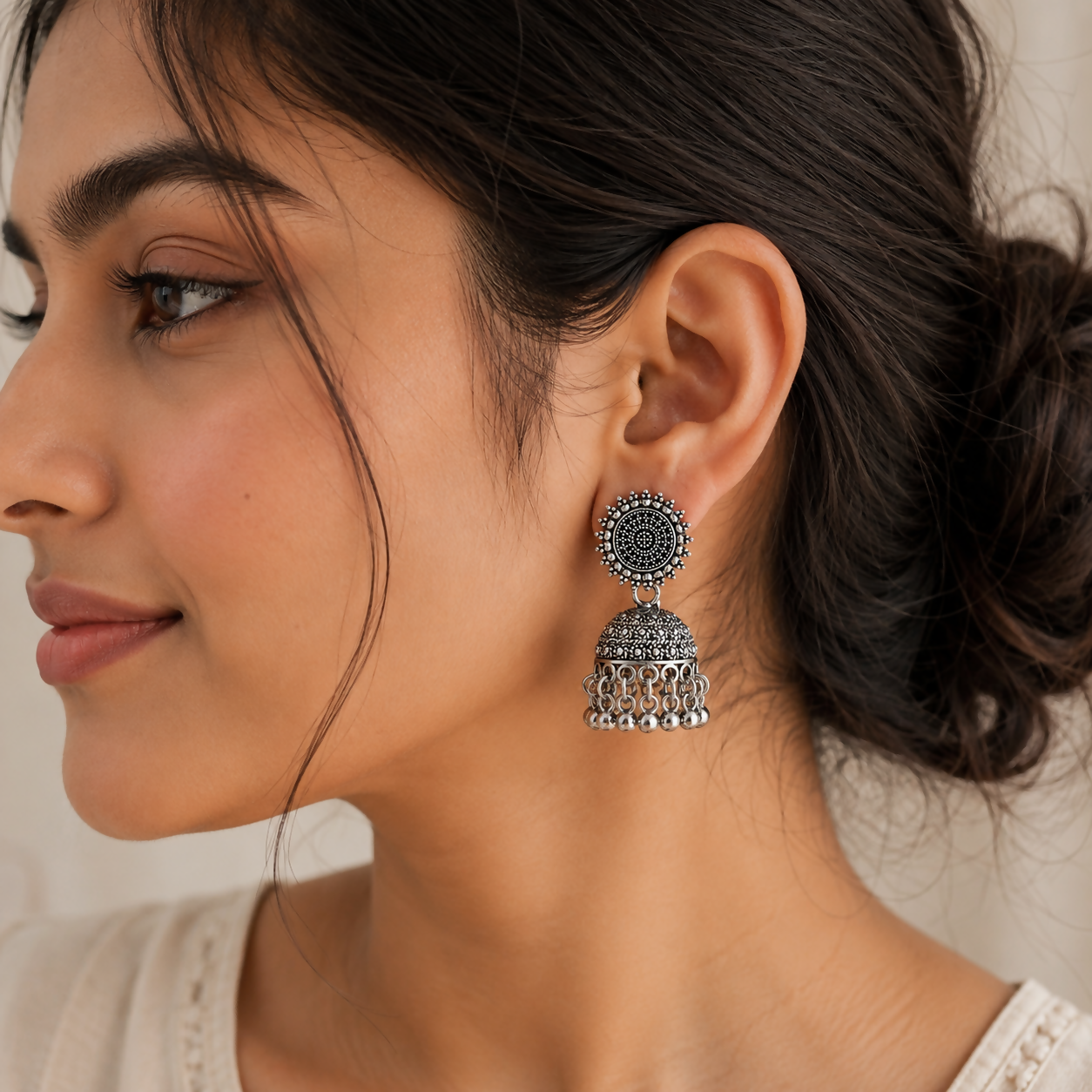 Model wearing elegant oxidised silver jhumka earrings, perfect for an ethnic look.