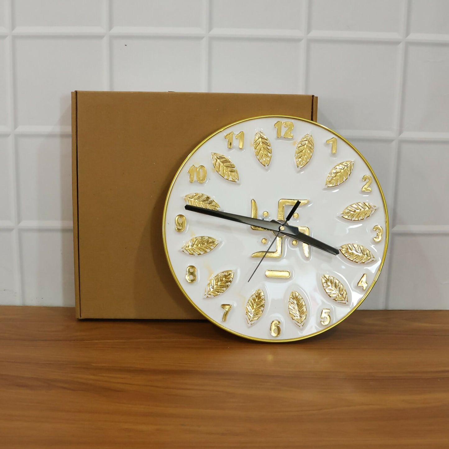 Decorative silver Swastik wall clock on a white wall background
