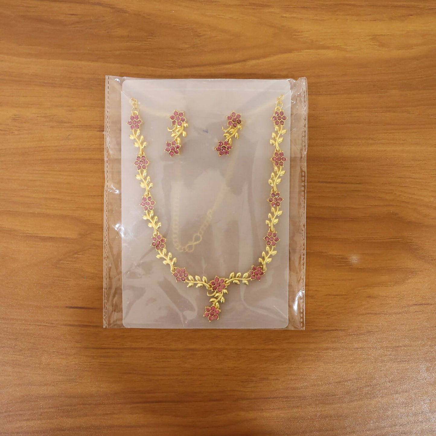 Front view of jewelry set featuring ruby floral motifs