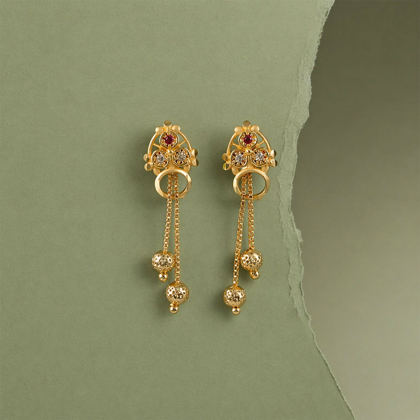 Side view of gold-plated stone studded dangle earrings