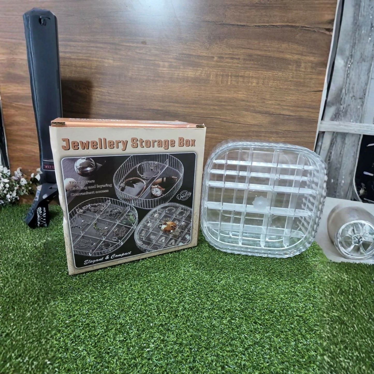 Close-up of the transparent jewelry box holding rings, earrings, & necklaces