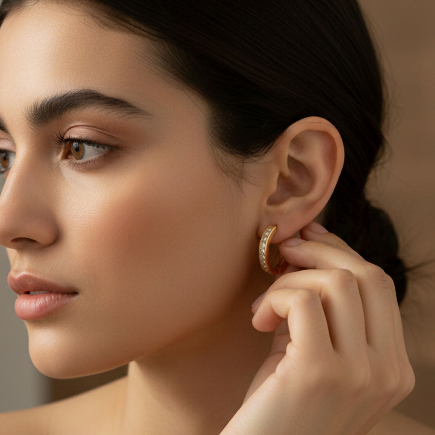 Elegant gold finish hoop earrings with crystal embellishments shown from side angle