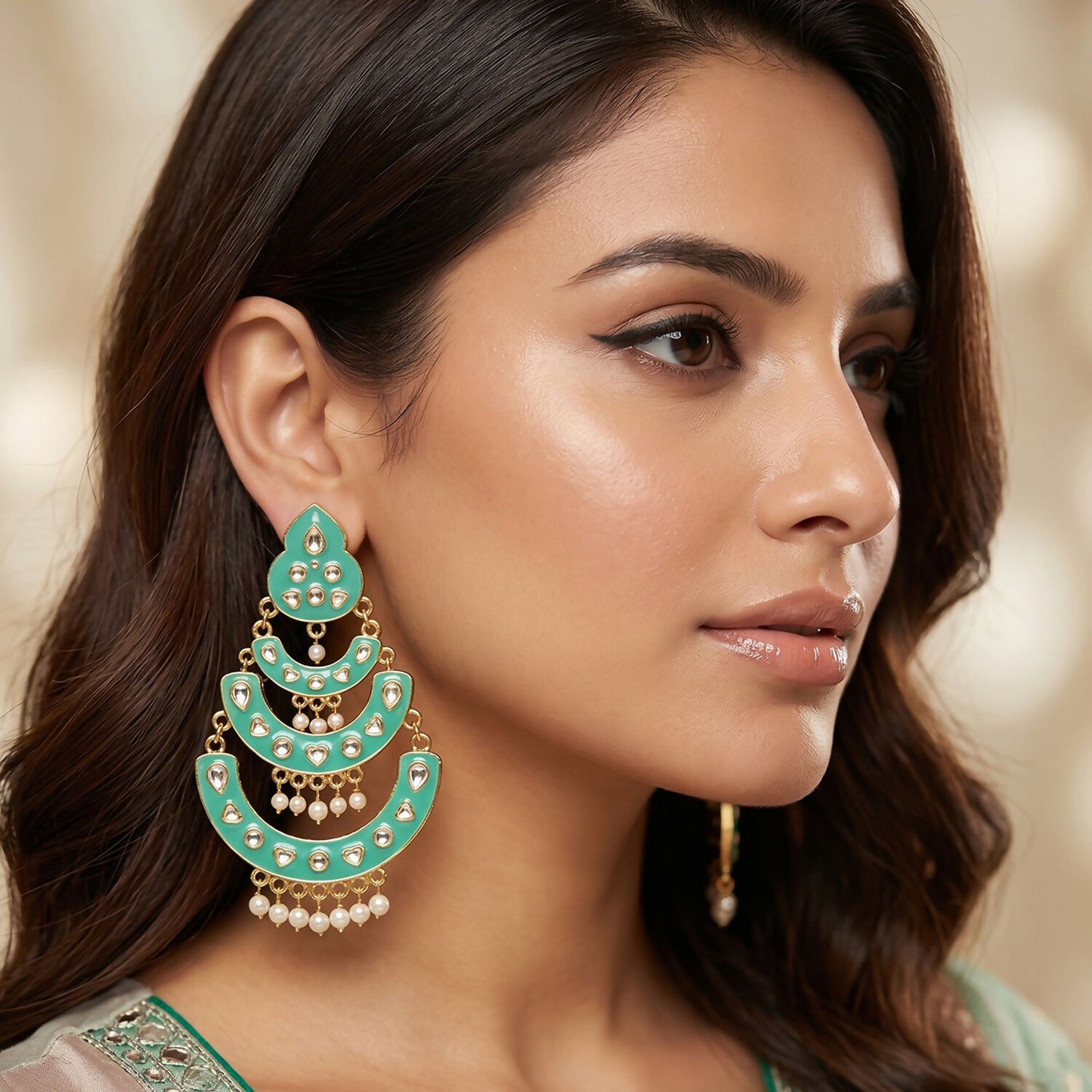 Close-up of sea green chandbali earrings with stone-style accents