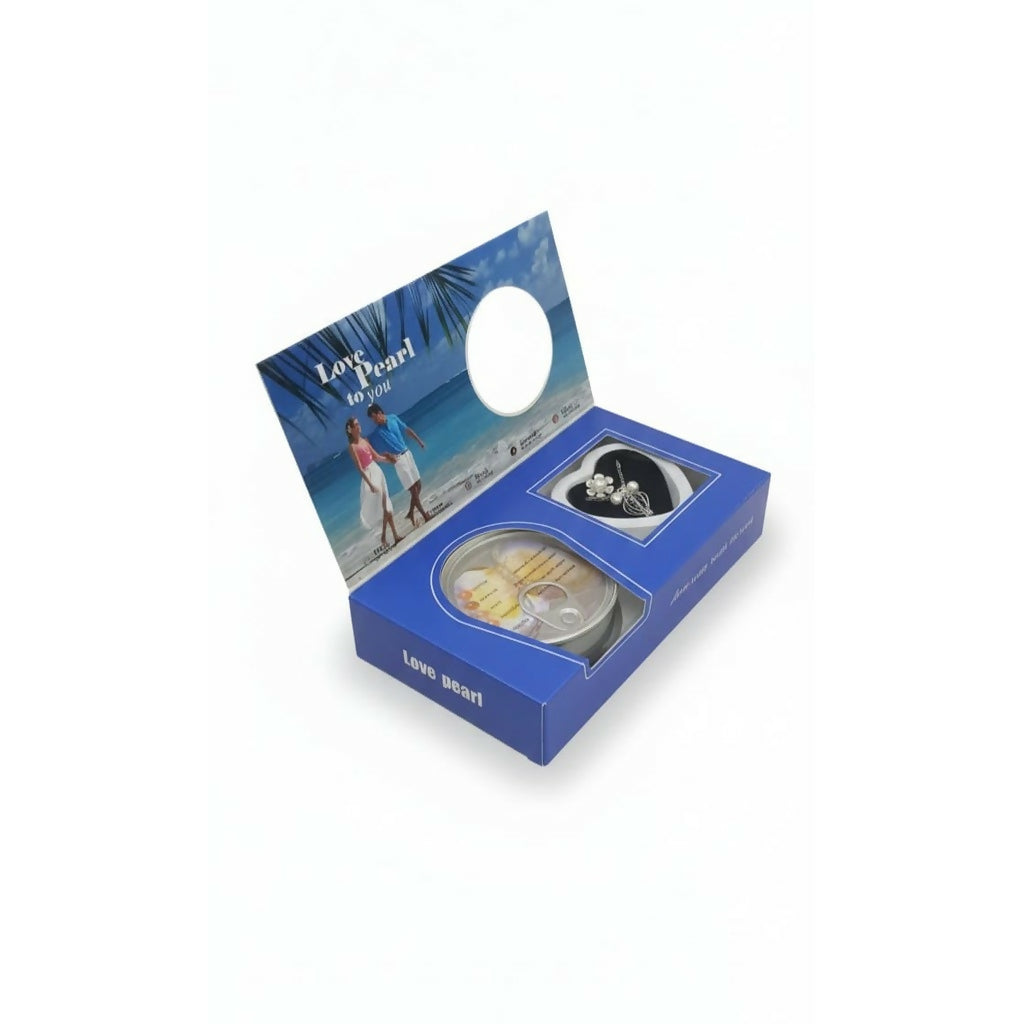 A blue gift box with an open lid, revealing a pearl pendant and a sealed oyster can.