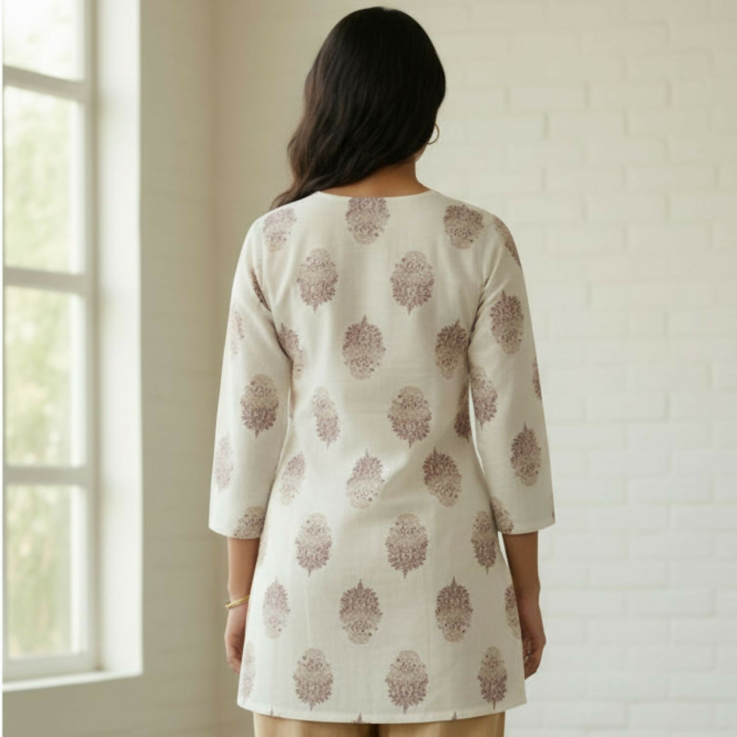 Close-up of white short kurti with vertical pintucks and mandarin collar