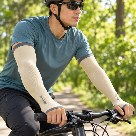 A man cycling outdoors wears beige arm sleeves with gray cuffs and thumb holes.