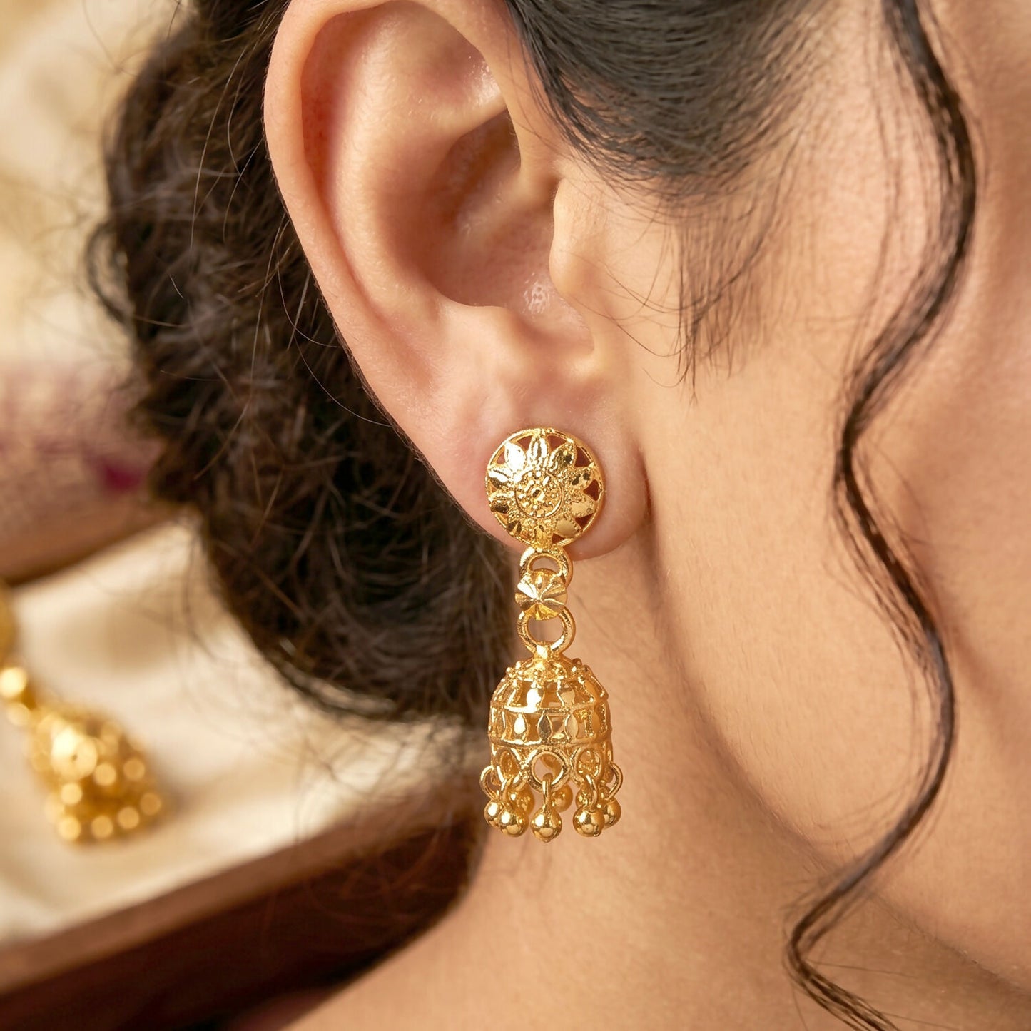 Close-up of pearl accents on gold-plated jhumka earrings