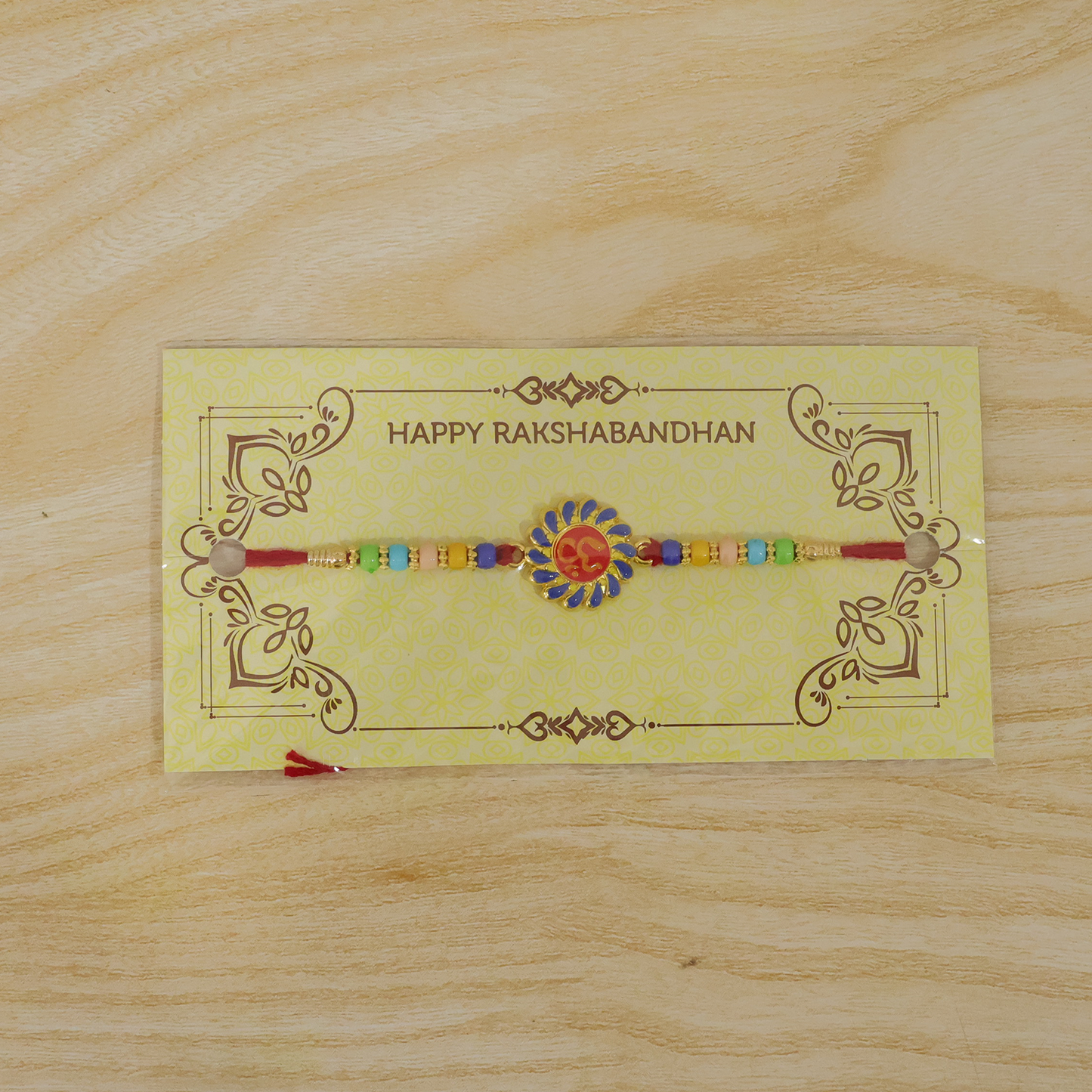 Om Designer Rakhi with vibrant beads shown on soft thread