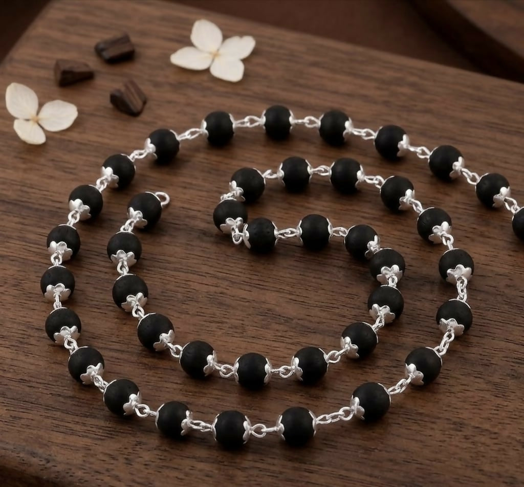 Close-up of Kalungi Mala showing 6mm matte black beads and detailed silver spacers