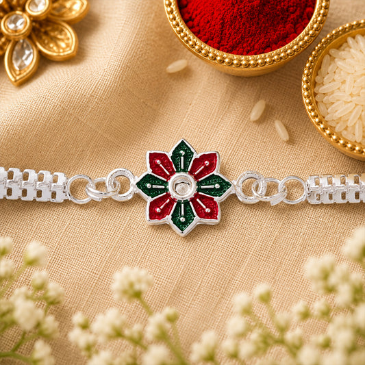 Close-up of a Star Floral Silver Rakhi with red and green enamel detailing.