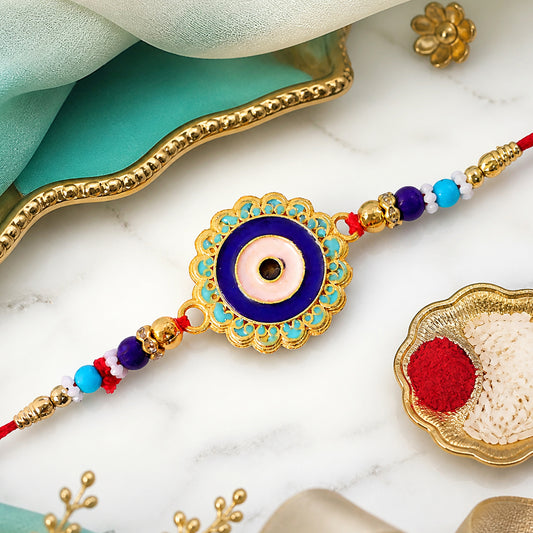Close-up of Evil Eye Rakhi with prominent blue beads and golden accents, showcasing intricate details.