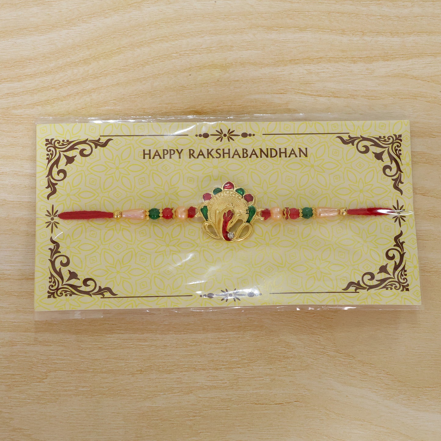 Om Ganesha Rakhi presented on a festive plate with traditional puja essentials.