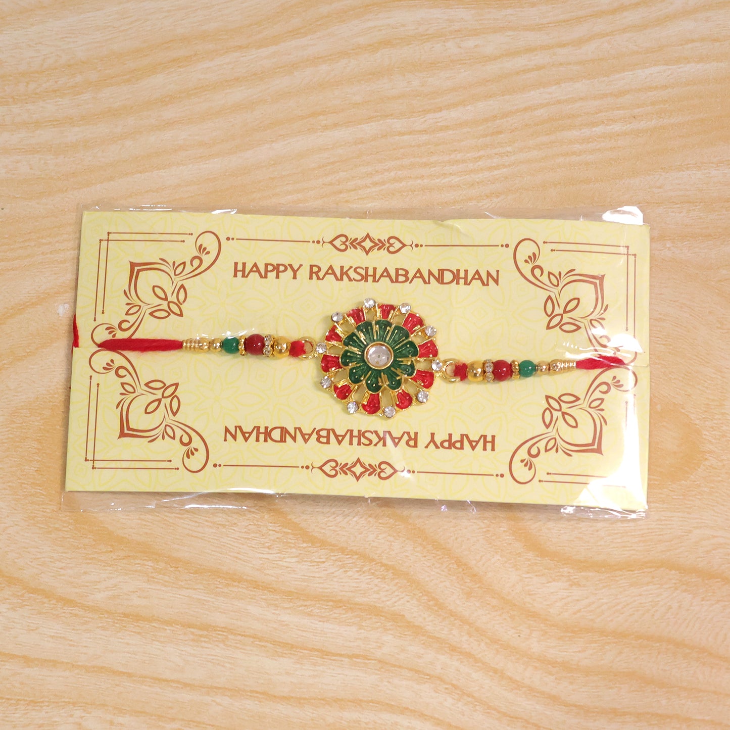 Detailed view of the red green beads and stone accents on the traditional Rakhi.
