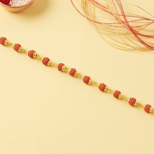 Rudraksha bead bracelet rakhi with gold plated caps on a brother's wrist.